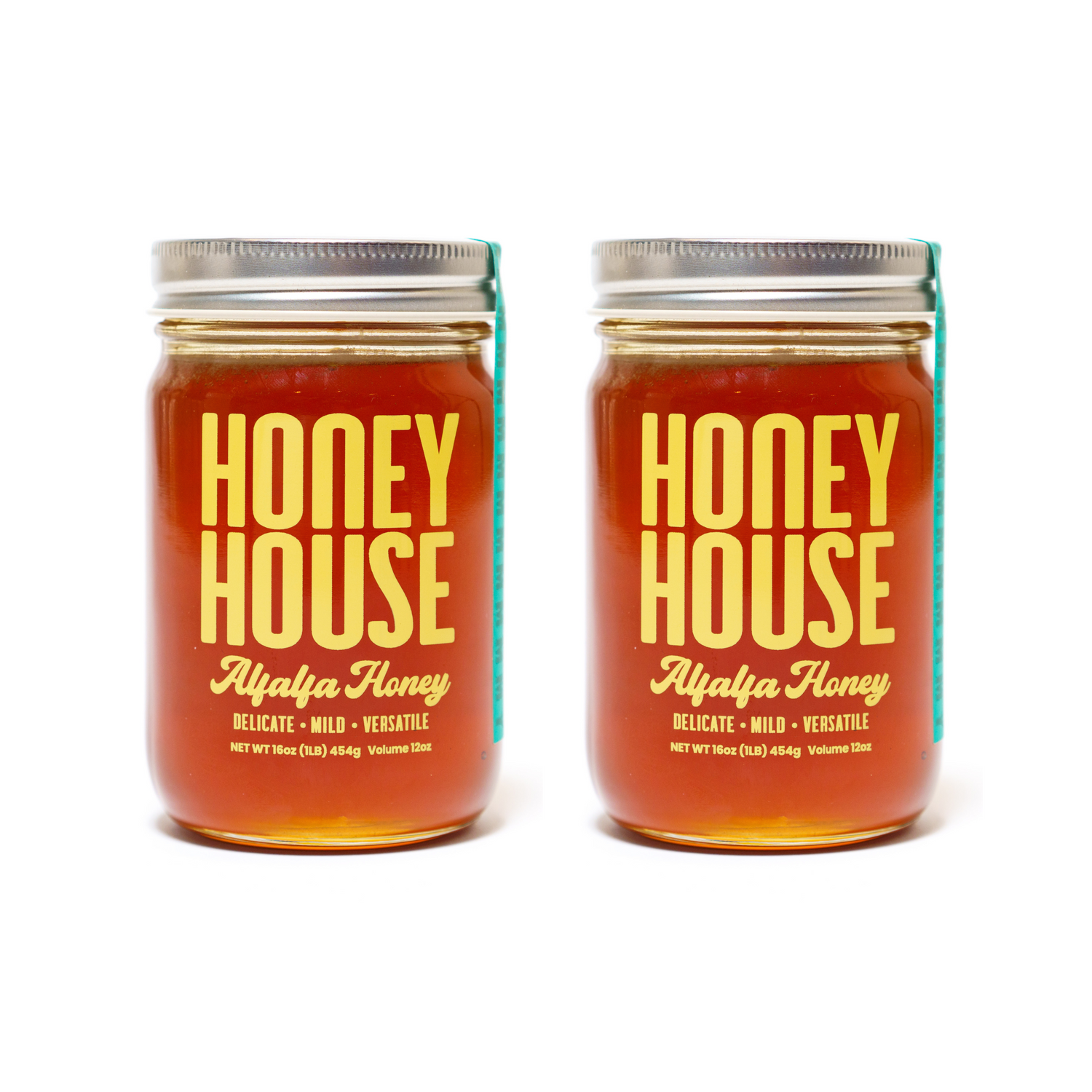 Two identical glass jars of Honey House Honey Alfalfa Honey with metal lids hold amber honey, rich in antioxidants. The labels say “Delicate • Mild • Versatile.” Both jars are shown side by side on a white background.