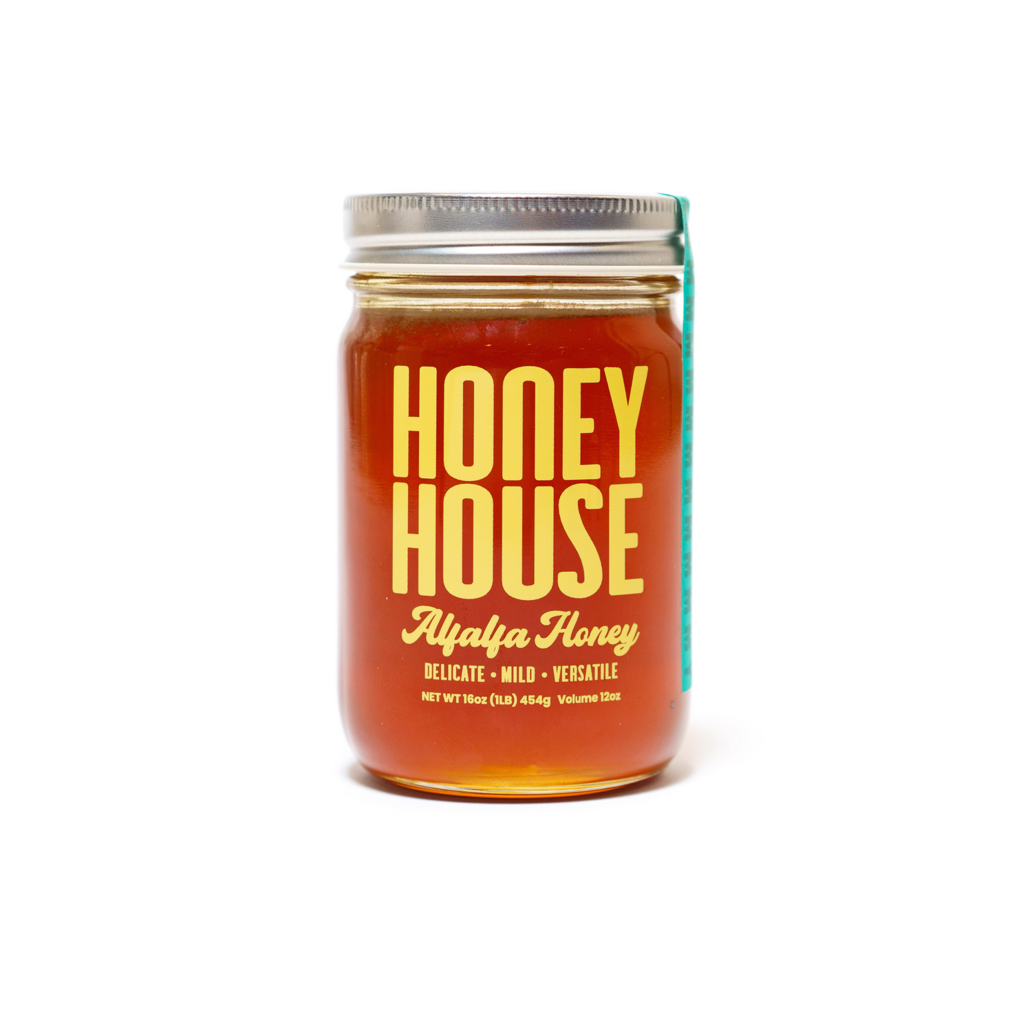 A glass jar of Honey House Honey Alfalfa Honey with a metal lid, filled with golden honey. The label states: Alfalfa Honey, Delicate • Mild • Versatile, Net Wt 16oz (1 lb.) 454g, Volume 315ml. Rich in natural antioxidants.