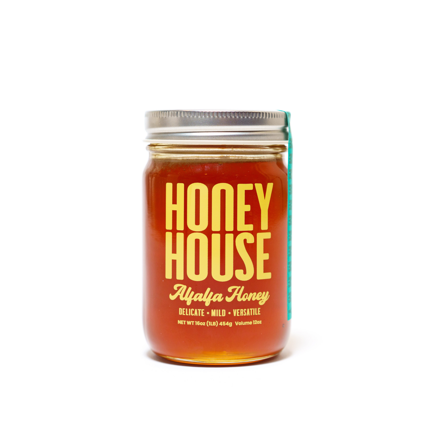 A 16oz (454g) glass jar of Honey House Honey Alfalfa Honey from Colorado, featuring a metal lid and amber honey. The label reads Delicate • Mild • Versatile. Rich in natural antioxidants.